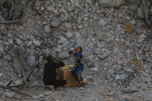epa12475841 A father and daughter eat in the rubble of destroyed buildings in the heavily damaged Sheikh Redwan neighborhood of Gaza City, 23 October 2025. The ceasefire between Israel and Hamas that is currently in place is part of the first phase of a Gaza peace plan that includes a halt in fighting, the release of hostages and prisoners, and the delivery...