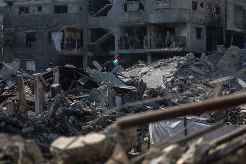 epa12475846 A Palestinian flag is hoisted in the rubble of destroyed buildings in the heavily damaged Sheikh Redwan neighborhood of Gaza City, 23 October 2025. The ceasefire between Israel and Hamas that is currently in place is part of the first phase of a Gaza peace plan that includes a halt in fighting, the release of hostages and prisoners, and the...