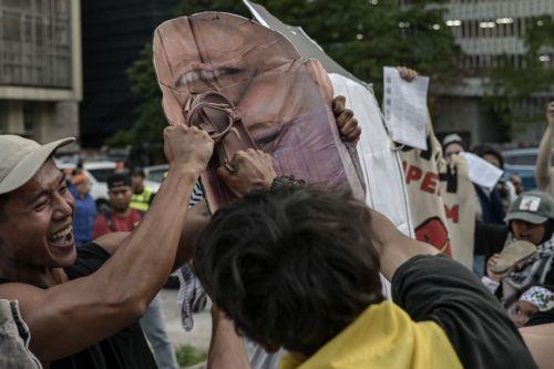 epa12483627 A protester throws a shoe against a photo of US President Donald Trump during a protest rally against US President Donald Trump's visit to Malaysia to attend the Association of Southeast Asian Nations (ASEAN) Summit at Ampang Park in Kuala Lumpur, Malaysia, 26 October 2025. Protesters gathered to oppose President Trump’s visit for the 47th ASEAN...