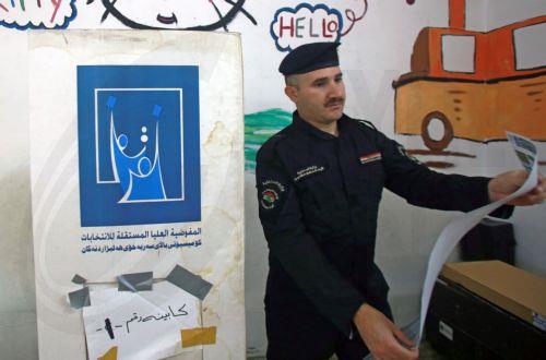 epa12513470 An Iraqi policeman holds a ballot paper during the early voting for the parliamentary elections, in Baghdad, Iraq, 09 November 2025. Members of the security forces and the military are casting their ballots in early voting for the Iraqi parliamentary elections before the general vote on 11 November.  EPA/CEERWAN AZIZ