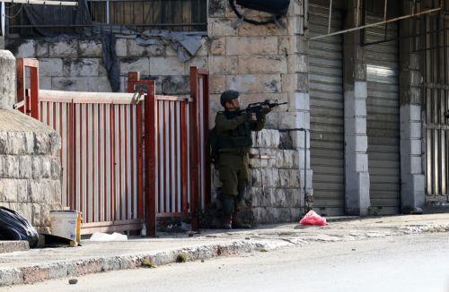 epa12537637 An Israeli soldier takes position during an Israeli military operation in the West Bank city of Nablus, 20 November 2025. According to the Palestinian Health Ministry, five Palestinians were wounded by Israeli soldiers. According to the Israeli army, one Israeli soldier was wounded.  EPA/ALAA BADARNEH