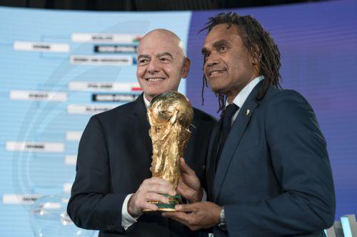 epa12537727 FIFA president Gianni Infantino (L) poses with Christian Karembeu and the FIFA World Cup Trophy during the FIFA World Cup 2026 play-offs draw at the Home of FIFA in Zurich, Switzerland, 20 November 2025.  EPA/CLAUDIO THOMA