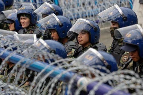 epa12539497 Philippine police keep watch from behind security barricades during an anti-corruption rally by predominantly college-level students in Manila, Philippines, 21 November 2025. President Marcos on 21 November announced that arrest warrants have been issued for a former congressman and 17 other individuals believed to be involved in anomalous...