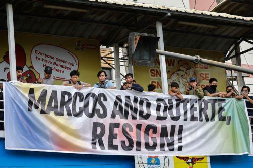 epa12539499 A banner calling for the resignation of Philippine President Ferdinand Marcos Jr. and Vice-President Sara Duterte hangs on a crossing bridge during an anti-corruption rally by predominantly college-level students in Manila, Philippines, 21 November 2025. President Marcos on 21 November announced that arrest warrants have been issued for a former...