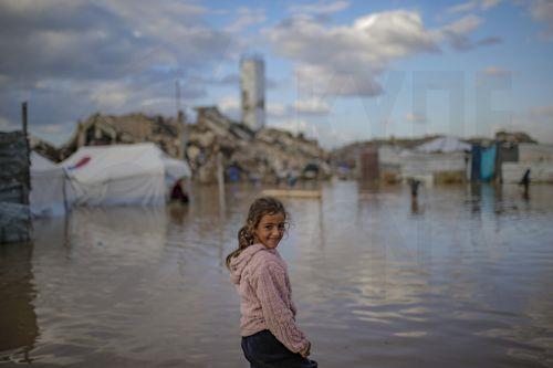 epa12548242 An internally displaced Palestinian girl stands in a puddle on a rainy day in Al Zaitun neighbourhood in the east of Gaza City, Gaza Strip, 25 November 2025. Around 1.9 million people in Gaza, nearly 90 percent of the population, have been displaced since the Israel-Hamas conflict began in October 2023, according to the UN.  EPA/MOHAMMED SABER