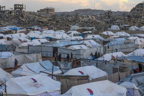 epa12548246 Tents of internally displaced Palestinians stand beside the ruins of destroyed buildings during a rainy day in Al Zaitun neighbourhood in the east of Gaza City, Gaza Strip, 25 November 2025. Around 1.9 million people in Gaza, nearly 90 percent of the population, have been displaced since the Israel-Hamas conflict began in October 2023, according...