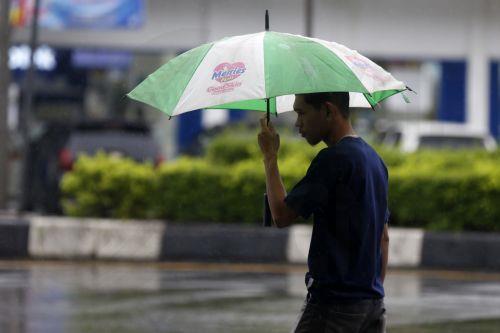 epa12549214 A man use an umbrella under heavy rain in Banda Aceh, Indonesia, 26 November 2025. The Meteorology, Climatology, and Geophysics Agency (BMKG) issued an early warning for extreme weather across the island of Sumatra, from Aceh to West Sumatra. The severe weather, including heavy rainfall with high intensity, has caused hydrological disasters such...
