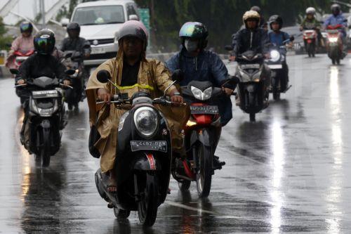 epa12549215 Motorist using raincoats drive under heavy rain in Banda Aceh, Indonesia, 26 November 2025. The Meteorology, Climatology, and Geophysics Agency (BMKG) issued an early warning for extreme weather across the island of Sumatra, from Aceh to West Sumatra. The severe weather, including heavy rainfall with high intensity, has caused hydrological...