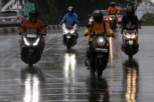 epa12549217 Motorist using raincoats drive under heavy rain in Banda Aceh, Indonesia, 26 November 2025. The Meteorology, Climatology, and Geophysics Agency (BMKG) issued an early warning for extreme weather across the island of Sumatra, from Aceh to West Sumatra. The severe weather, including heavy rainfall with high intensity, has caused hydrological...