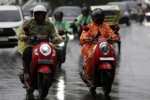 epa12549218 Motorist using raincoats drive under heavy rain in Banda Aceh, Indonesia, 26 November 2025. The Meteorology, Climatology, and Geophysics Agency (BMKG) issued an early warning for extreme weather across the island of Sumatra, from Aceh to West Sumatra. The severe weather, including heavy rainfall with high intensity, has caused hydrological...