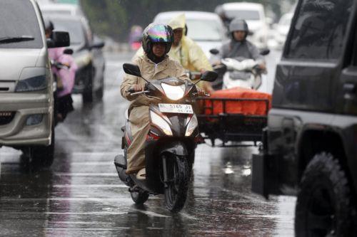 epa12549219 Motorist using raincoats drive under heavy rain in Banda Aceh, Indonesia, 26 November 2025. The Meteorology, Climatology, and Geophysics Agency (BMKG) issued an early warning for extreme weather across the island of Sumatra, from Aceh to West Sumatra. The severe weather, including heavy rainfall with high intensity, has caused hydrological...