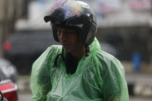 epa12549222 A motorist using a raincoat drives under heavy rain in Banda Aceh, Indonesia, 26 November 2025. The Meteorology, Climatology, and Geophysics Agency (BMKG) issued an early warning for extreme weather across the island of Sumatra, from Aceh to West Sumatra. The severe weather, including heavy rainfall with high intensity, has caused hydrological...