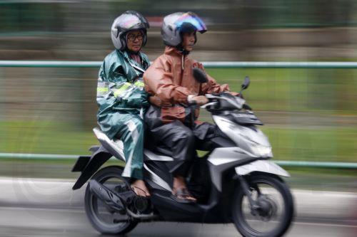 epa12549224 Motorist using raincoats drive under heavy rain in Banda Aceh, Indonesia, 26 November 2025. The Meteorology, Climatology, and Geophysics Agency (BMKG) issued an early warning for extreme weather across the island of Sumatra, from Aceh to West Sumatra. The severe weather, including heavy rainfall with high intensity, has caused hydrological...