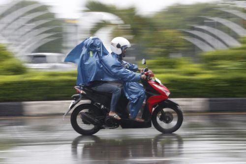 epa12549225 Motorist using raincoats drive under heavy rain in Banda Aceh, Indonesia, 26 November 2025. The Meteorology, Climatology, and Geophysics Agency (BMKG) issued an early warning for extreme weather across the island of Sumatra, from Aceh to West Sumatra. The severe weather, including heavy rainfall with high intensity, has caused hydrological...