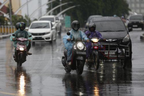 epa12549226 Motorist using raincoats drive under heavy rain in Banda Aceh, Indonesia, 26 November 2025. The Meteorology, Climatology, and Geophysics Agency (BMKG) issued an early warning for extreme weather across the island of Sumatra, from Aceh to West Sumatra. The severe weather, including heavy rainfall with high intensity, has caused hydrological...