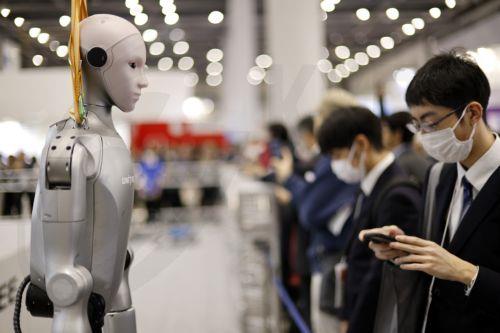 epa12566628 A visitor stands next to a humanoid robot at the TechShare booth during the International Robot Exhibition 2025 (iREX2025) in Tokyo, Japan, 03 December 2025. Held once every two years, the iREX is one of the world’s largest robot trade shows. For the 2025 edition, 673 companies and organizations will be presenting their latest robot technologies...