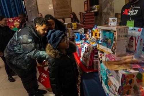 epa12573440 Parents help children pick out holiday gifts inside Bronx Borough Hall during the annual Christmas tree lighting at Lou Gehrig Plaza in the Bronx borough of New York, New York, USA, 05 December 2025.  EPA/MADISON STEWART