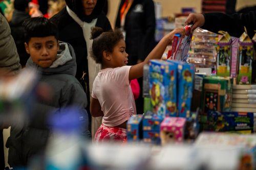 epa12573444 A child looks through toys and games set out for families inside Bronx Borough Hall during the annual Christmas tree lighting at Lou Gehrig Plaza in the Bronx borough of New York, New York, USA, 05 December 2025.  EPA/MADISON STEWART
