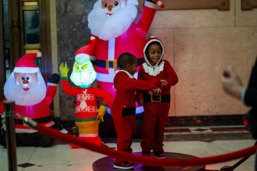 epa12573445 Two kids in Santa outfits dance inside the Bronx Borough Hall gift distribution during the annual Christmas tree lighting at Lou Gehrig Plaza in the Bronx borough of New York, New York, USA, 05 December 2025.  EPA/MADISON STEWART