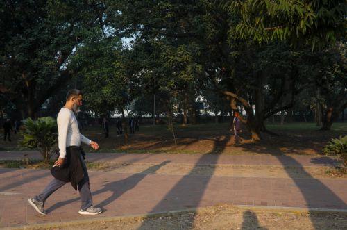 epa12576209 A man takes a walk during the early winter morning at Ramna Park in Dhaka, Bangladesh, 07 December 2025. Ramna Park is a large recreation area situated at the heart of the central Dhaka.  EPA/MONIRUL ALAM