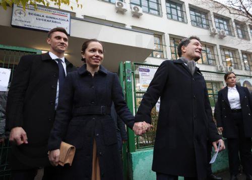 epa12576432 Romanian President Nicusor Dan (2-R), accompanied by his partner Mirabela Gradinaru (2-L), leaves the polling station after casting his vote in the capital's mayoral elections, in Bucharest, Romania, 07 December 2025. The Romanian capital, Bucharest, holds its early mayoral elections on 07 December, following Nicusor Dan's ascent from mayor to...