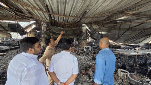 epa12576539 Police officials investigate the burned-out interior at the site of the Goa nightclub fire in Goa, India, 07 December 2025. At least 25 people were killed and six others were injured in a massive fire that erupted at a nightclub in Goa, police said.  EPA/STR