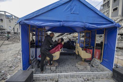 epa12578941 Palestinians get a haircut at a makeshift tent set up near the ruins of destroyed buildings in the Al Sheikh Radwan neighborhood of Gaza City, Gaza Strip, 08 December 2025, amid a ceasefire between Israel and Hamas. Around 1.9 million people in Gaza, nearly 90 percent of the population, have been displaced since the Israel-Hamas conflict began...