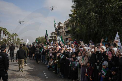 epa12578983 People watch as Syrian army soldiers march during a parade marking the first anniversary of the ousting of the Bashar Al-Assad regime in Damascus, Syria, 08 December 2025. Syria marks the first anniversary of the overthrow of the Assad regime on 08 December when the dictatorship of Bashar al-Assad collapsed during a major offensive by opposition...