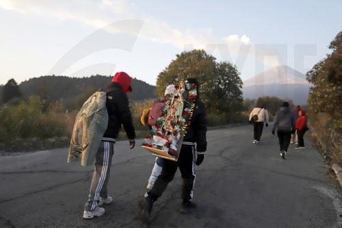 epa12581904 A person carries a religious image during a pilgrimage to the Basilica of Guadalupe in Paso de Cortes mountain pass in Puebla state, Mexico, 09 December 2025. Hundreds of Mexican faithful began their annual pilgrimage to the Shrine of the Virgin of Guadalupe this week, which is expected to draw millions of visitors marking the 494th anniversary...
