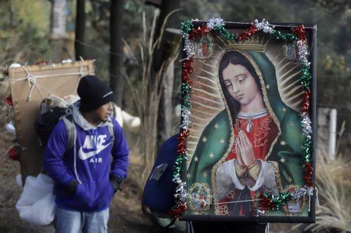 epa12581908 A person carries a religious image during a pilgrimage to the Basilica of Guadalupe in Paso de Cortes mountain pass in Puebla state, Mexico, 09 December 2025. Hundreds of Mexican faithful began their annual pilgrimage to the Shrine of the Virgin of Guadalupe this week, which is expected to draw millions of visitors marking the 494th anniversary...