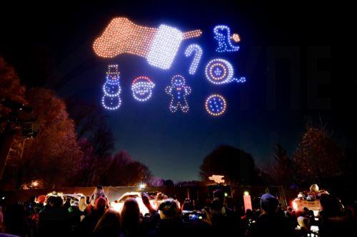 epa12582013 Visitors watch a sponsored Christmas holiday drone display at Piedmont Park in Atlanta, Georgia, USA, 09 December 2025. The show 'Chevy Holiday Magic' was sponsored by automobile manufacturer Chevrolet and featured 1,000 choreographed drones.  EPA/ERIK S. LESSER