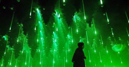 epa12585131 People skate on an ice rink in the art installation 'Forest - Winterlights 2025' by light and media artist Christopher Bauder at his Dark Matter art gallery in Berlin, Germany, 11 December 2025. Berlin-based light and media artist Bauder has created a poetic forest landscape covering 1,000 square metres, featuring over 600 trees, most of which...