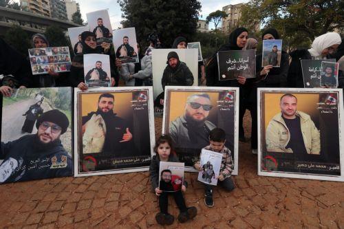 epa12587536 Activists and relatives of detainees in Israeli prisons carry pictures of the Lebanese prisoners in Israeli jails, during a protest outside the United Nations Economic and Social Commission for Western Asia (UN-ESCWA) headquarters in Beirut, Lebanon, 12 December 2025. Activists and relatives of detainees in Israeli prisons gather for a protest...
