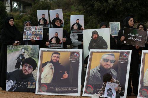 epa12587537 Activists and relatives of detainees in Israeli prisons carry pictures of the Lebanese prisoners in Israeli jails, during a protest outside the United Nations Economic and Social Commission for Western Asia (UN-ESCWA) headquarters in Beirut, Lebanon, 12 December 2025. Activists and relatives of detainees in Israeli prisons gather for a protest...