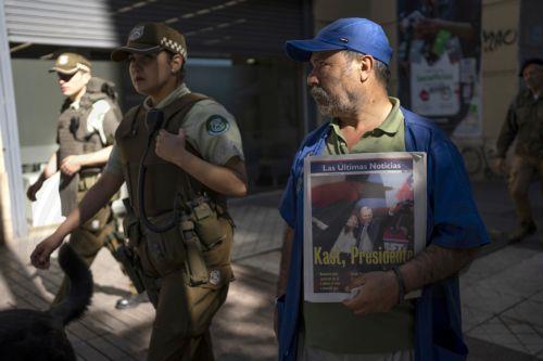 epa12594399 A man holds a newspaper announcing the results of the presidential elections in Santiago, Chile, 15 December 2025. The far-right Jose Antonio Kast won the second round of the presidential elections in Chile on 14 December.  EPA/ADRIANA THOMASA