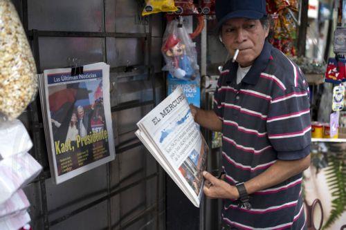 epa12594401 A man reads a newspaper announcing the results of the presidential elections in Santiago, Chile, 15 December 2025. The far-right Jose Antonio Kast won the second round of the presidential elections in Chile on 14 December.  EPA/ADRIANA THOMASA