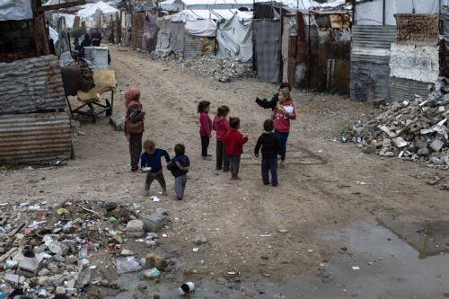 epa12594413 Displaced Palestinian children play in front of their tents on a rainy day in the city of Khan Younis, in the southern Gaza Strip, 15 December, 2025.  According to the UN around 90 percent of the population or 1.9 million people in Gaza have been displaced since the start of the conflict.  EPA/HAITHAM IMAD