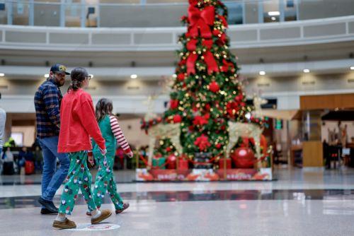 epa12609411 Young travelers wear holiday pajamas while transiting through Hartsfield-Jackson Atlanta International Airport during the busy Christmas holiday travel season in Atlanta, Georgia, USA, 22 December 2025. Weather could cause delays for both air travelers and drivers.  EPA/ERIK S. LESSER