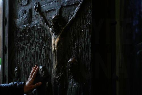 epa12615218 A pilgrim touches the the St. Paul Outside the Walls Basilica’s Holy Door prior to the start of its closing ceremony in Rome, Italy, 28 December 2025.The rite marks one of the final ceremonial closures of Holy Doors across the city's major papal basilicas ahead of the formal conclusion of the Catholic Church's 2025 Jubilee Year, which will end...
