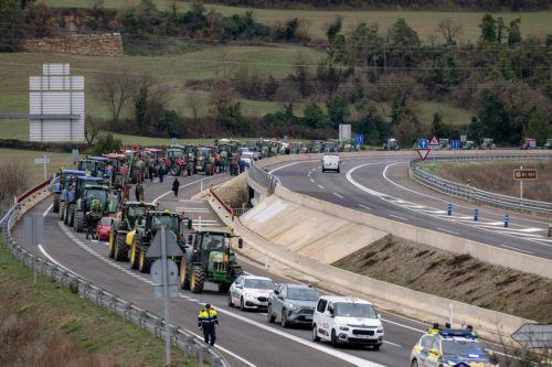 epa12616720 Tractors drive on the C-25 motorway as it passes through Cervera, Lleida, Spain, 29 December 2025. Agricultural union Unio de Pagesos (UP) organized a protest with tractors to block the connection between Lleida and Girona in protest against the 'mismanagement of game animals' and to demand better prevention of livestock diseases such as the...