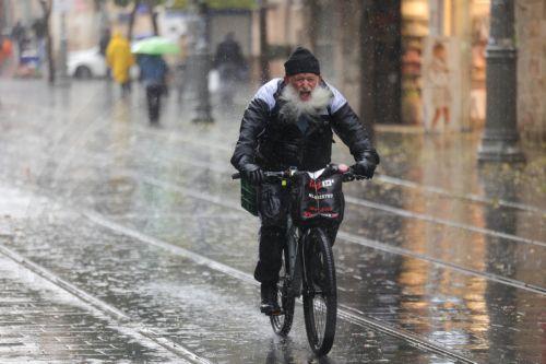 epa12616728 People walk in the rain during a stormy day in downtown Jerusalem, 29 December 2025. According to the Israel Meteorological Service, northern and central Israel, including Jerusalem, will experience occasional showers and isolated thunderstorms today, with strong westerly winds prevailing in most regions.  EPA/ABIR SULTAN