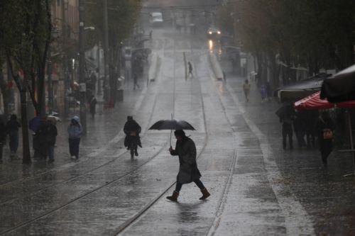 epa12616729 People walk in the rain during a stormy day in downtown Jerusalem, 29 December 2025. According to the Israel Meteorological Service, northern and central Israel, including Jerusalem, will experience occasional showers and isolated thunderstorms today, with strong westerly winds prevailing in most regions.  EPA/ABIR SULTAN