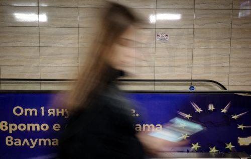epa12616782 A slow-shutter photo shows a woman passing a euro adoption poster in Sofia, Bulgaria, 29 December 2025. Bulgaria is set to become the 21st member of the eurozone on 01 January 2026, transitioning from the national lev to the euro amid public concerns that the move could trigger immediate price hikes and a higher cost of living.  EPA/BORISLAV...