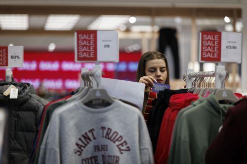 epa12616802 A shop worker places reduced price tags at a clothes shop on Oxford Street as people do their winter sale shopping after Boxing Day sales in London, Britain, 29 December 2025. Early data on the morning of Boxing Day 2025 suggested a decline; however, a later evening surge pushed overall footfall across UK retail destinations, including high...