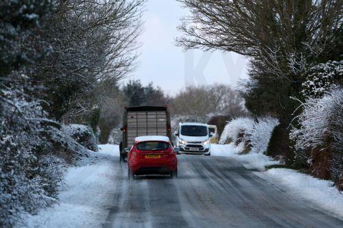 epa12621416 Motorists drive on a snow-covered road in Mold, Britain, 02 January 2026. Areas of Scotland, Wales, and England are under yellow and amber Met Office weather warnings for snow and ice, as cold arctic air from Scandinavia moves across the UK.  EPA/ADAM VAUGHAN