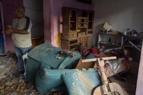 epa12627774 A person looks at a building damaged by an explosive device, in Catia La Mar, Venezuela, 04 January 2026.  EPA/MIGUEL GUTIÉRREZ