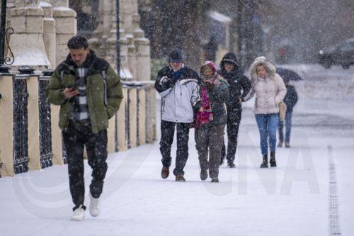 epa12628325 People walk on a street amid snow in Teruel, central Spain, 05 January 2026, due to Storm Francis.  EPA/ANTONIO GARCIA