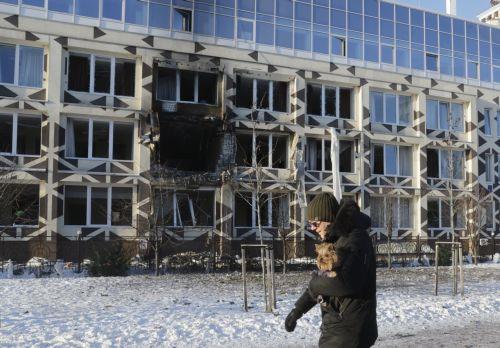 epa12628349 A man holding a dog walks near the site of a Russian drone strike on a private medical clinic in Kyiv, Ukraine, 05 January 2026, amid the Russian invasion. At least one person was killed and three others were injured as a result of the attack, according to the State Emergency Service of Ukraine.  EPA/SERGEY DOLZHENKO