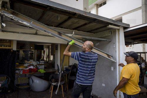 epa12632535 Government workers clean debris from a house damaged by the US attack in Caracas, Venezuela, 06 January 2026. Broken glass, bullet holes, dust, and paint remnants cover furniture and floors in several homes in a Caracas neighborhood affected by the US attack last 03 January, which culminated in the capture of President Nicolas Maduro and his...