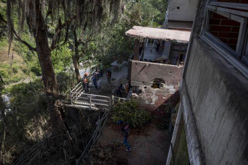 epa12632539 Government workers clean debris from a house damaged by the US attack in Caracas, Venezuela, 06 January 2026. Broken glass, bullet holes, dust, and paint remnants cover furniture and floors in several homes in a Caracas neighborhood affected by the US attack last 03 January, which culminated in the capture of President Nicolas Maduro and his...
